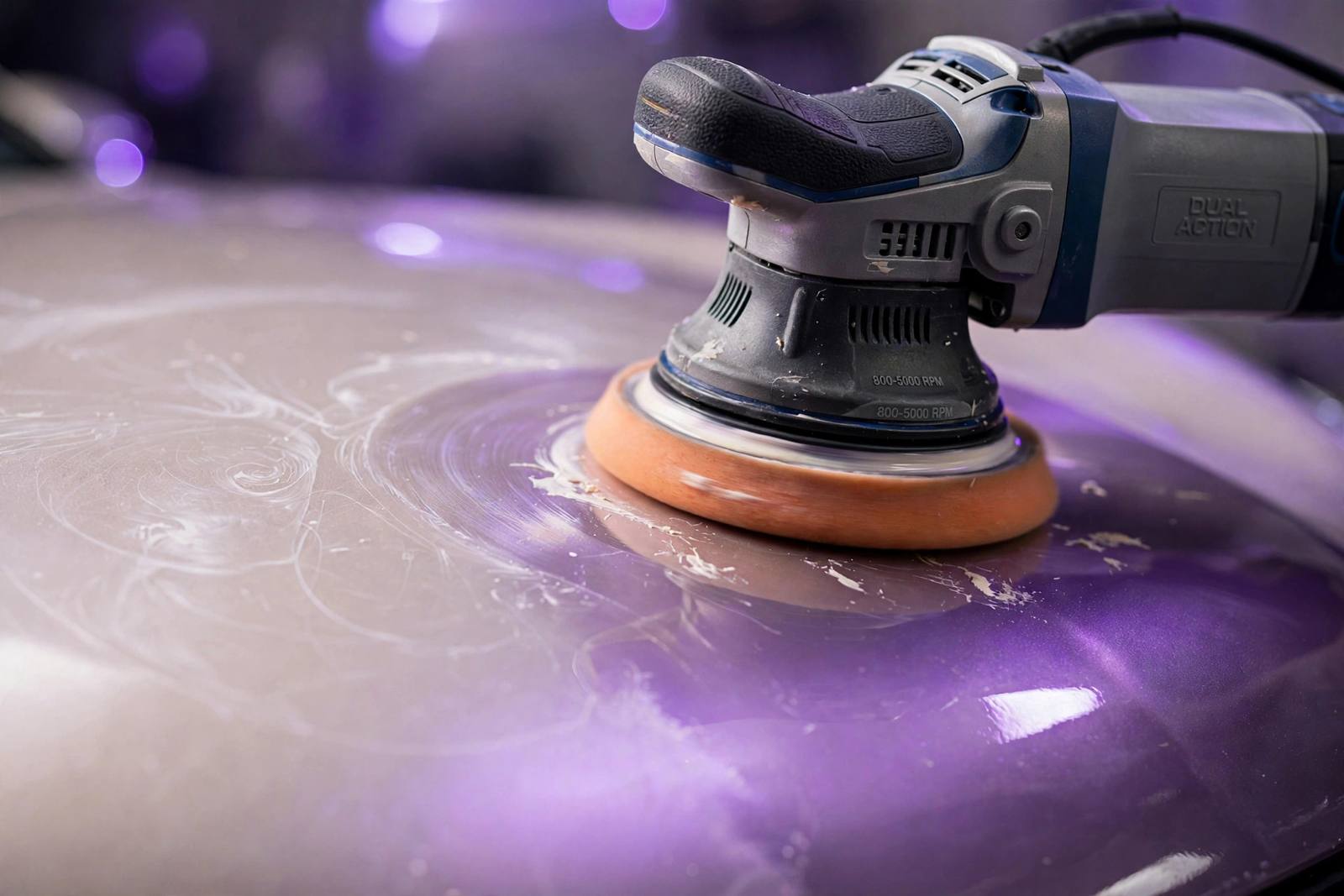 Machine polisher correcting the paint on a car panel